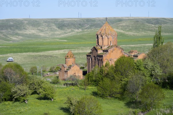 Historic church in the middle of a green landscape with hills and clear skies, Marmashen Monastery,