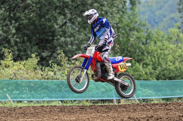 Motocross, Rudersberg, Baden-Württemberg, Germany, Europe, A rider dressed in blue jumps with his