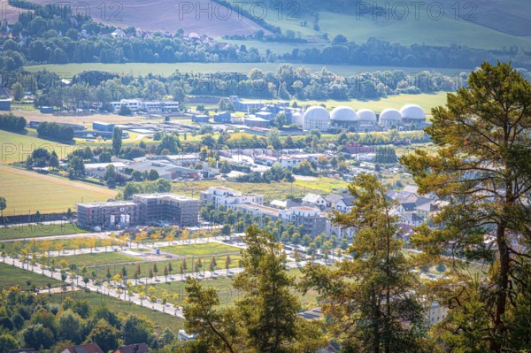 View of the residential area at Ölste with industrial buildings and trees in the foreground, Jena,
