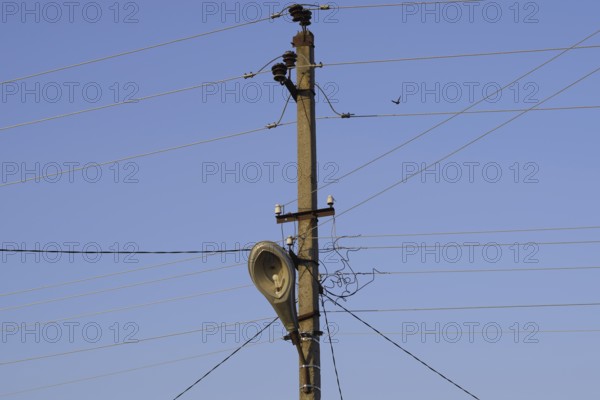 Power line post with a street lighting lamp. Krasnodar, Russia
