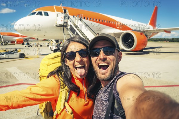 Young happy caucasian couple taking selfie portrait on departure or arrival destination for