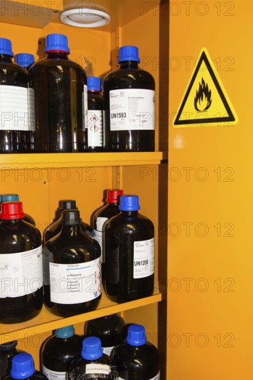 Flammable Chemicals In Bottles With Different Size in Orange Protection Cabinet, Marked With A