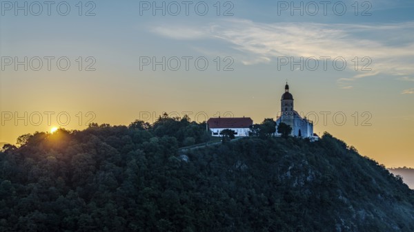 The sunrise illuminates the pilgrimage church of the Assumption of the Virgin Mary on the Bogenberg
