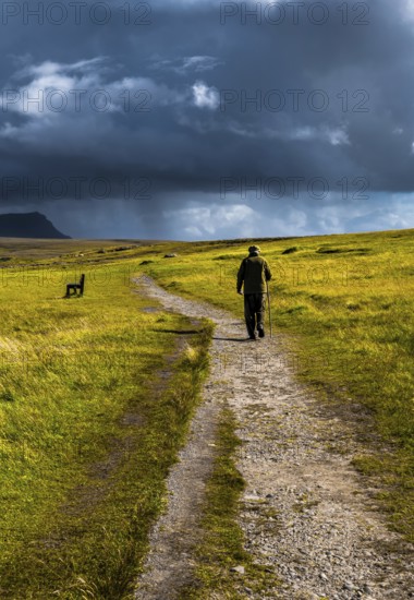 Old Man With Walking Stick Strolls On Narrow Gravel Path Through Scenic Landscape With Spectacular
