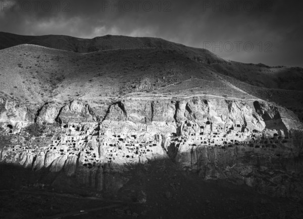 Black and white dramatic landscape of Vardzia, cave city. Georgia. Unique and mysterious places in