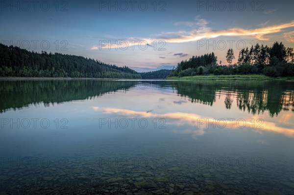 Reflection of clouds and trees in the water at sunset in a calm atmosphere, Zeulenrodaer Meer