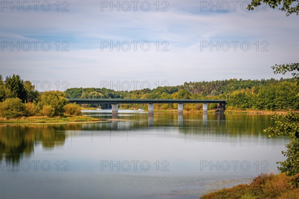 View of a bridge surrounded by green trees and a clear sky, Zeulenrodaer Meer reservoir,