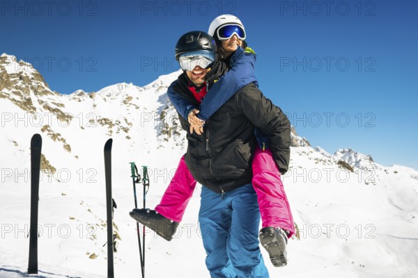 Happy young caucasian adult skiers couple in love having fun together playing enjoy leisure