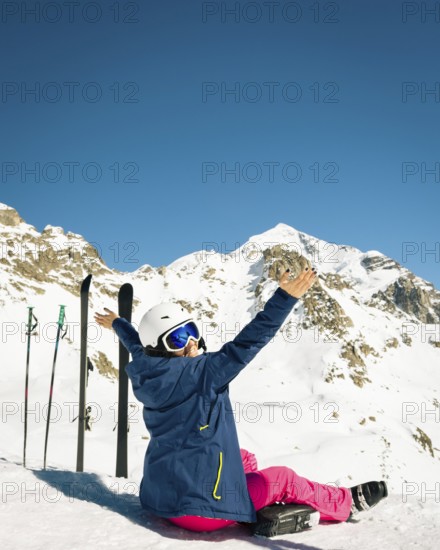 Young happy caucasian woman pose with skis arms outstretched in high mountains. Get away skiing