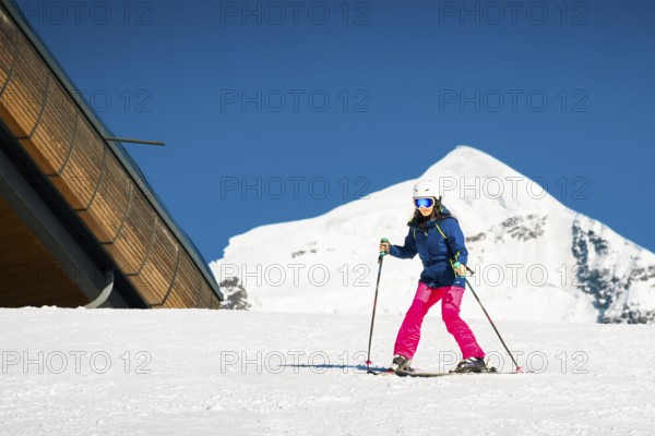 Young caucasian woman beginner skier on slope learn enjoy ski downhill in beautiful sunny day with