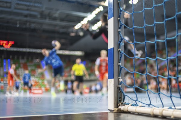 Detail of handball goal post with net and handball match in the background. handball match. Lubin,