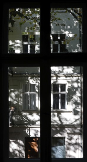 View through a window to an opposite facade of a multi-storey residential building with classical