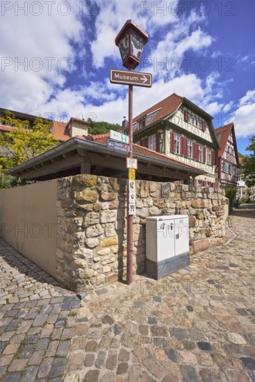 Old town, lantern, signpost to the museum, quarry stone wall, historic half-timbered houses,