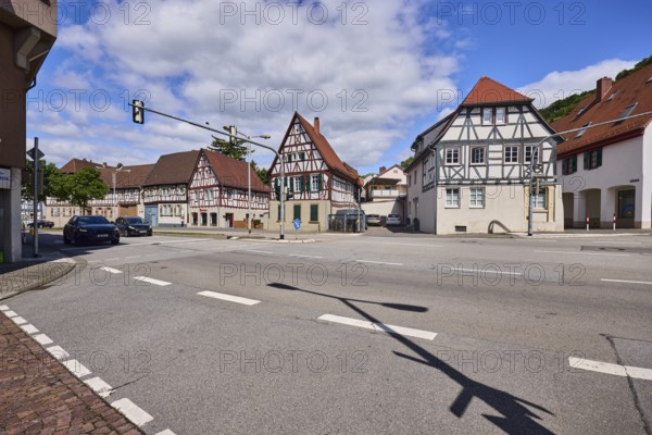 Half-timbered houses, pointed roof with red roof tiles, traffic lights, streets, vehicles, blue