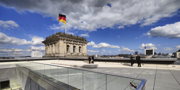 Roof terrace with a German flag in the wind on one of the corner towers of the Reichstag building,