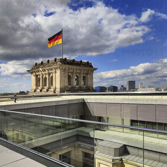 Viewing platform with a German flag in the wind on one of the corner towers of the Reichstag