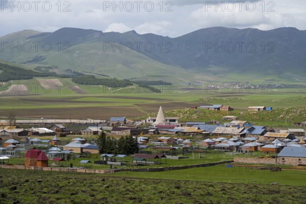 A small village in a green mountain landscape with scattered houses and fields, Yazidi temple, Rya