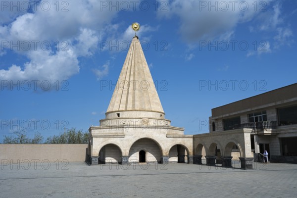A large stone mausoleum with a dome against a clear blue sky, Yazidi temple, Shekhubekir,