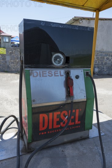 An old diesel pump at a petrol station with a large sign, diesel fuel pump, petrol station, petrol