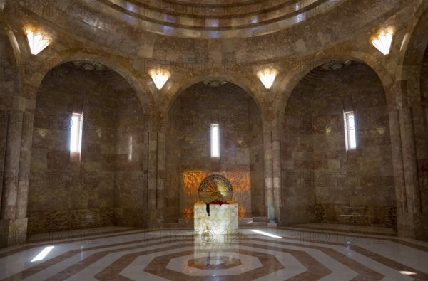 An impressive hall with a vaulted ceiling and marble floor in golden tones, light floods in through