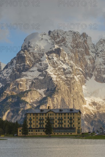 View over Lake Misurina to a building on the shore of the lake with a view towards the Sorapis