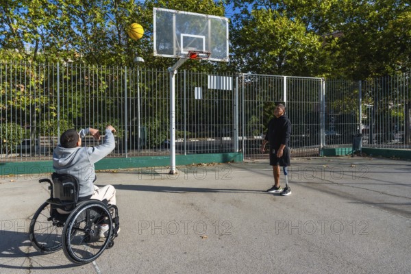Two disabled friends are enjoying a game of basketball on an outdoor court, with one man in a