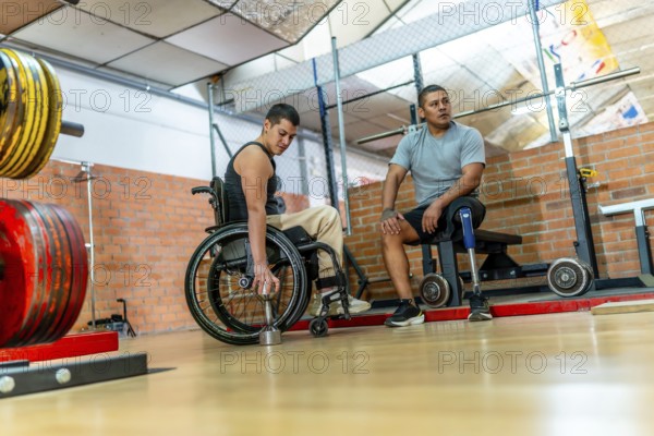 Adaptive athletes with physical disabilities engaging in training at a gym, one man in a wheelchair