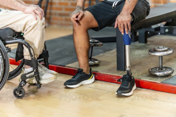 Disabled men, one in a wheelchair and another with a prosthetic leg, sharing a moment of