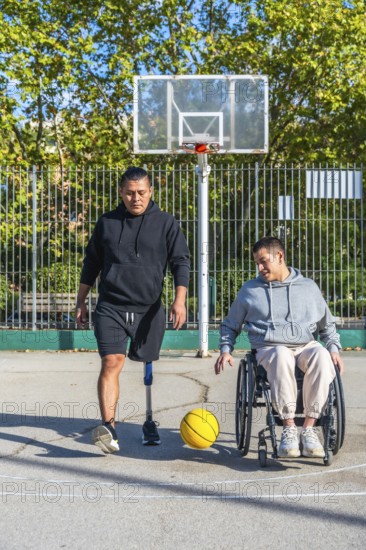 Two friends play basketball on an outdoor court, one man with a prosthetic leg, the other in a