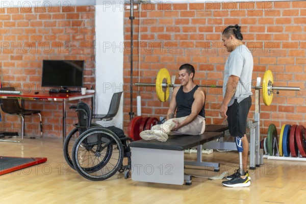 Two adaptive athletesone with a prosthetic leg and one using a wheelchairsupport each other during