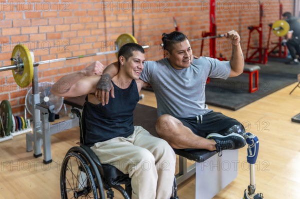 Two smiling men, one using a wheelchair and the other a prosthetic leg, warmly embracing each other