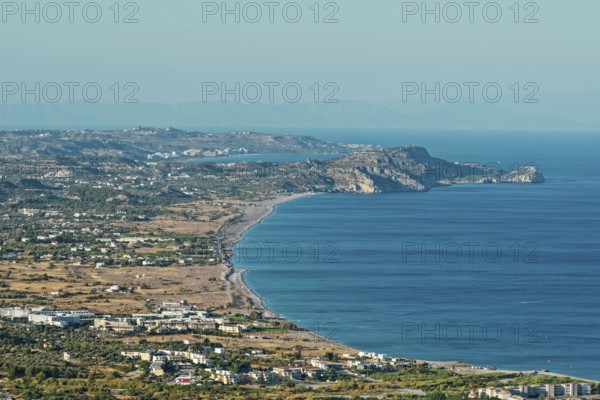Wide coastline of Kolymbia with sandy beach and blue sea under a clear sky, Church of the Virgin