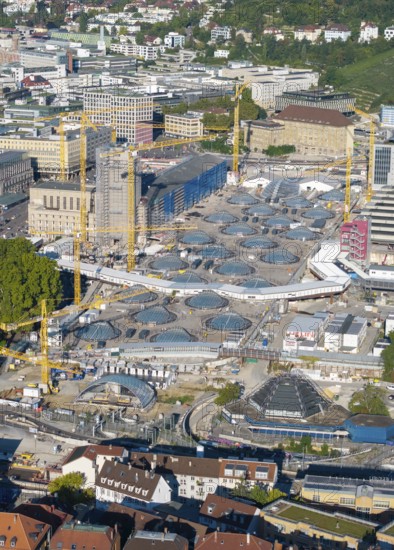 Large construction site in the city with numerous cranes and modern building structures on a sunny