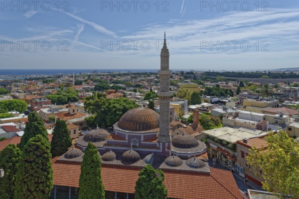 A panoramic view with minaret and domes in front of a cityscape of Rhodes and the sea in the