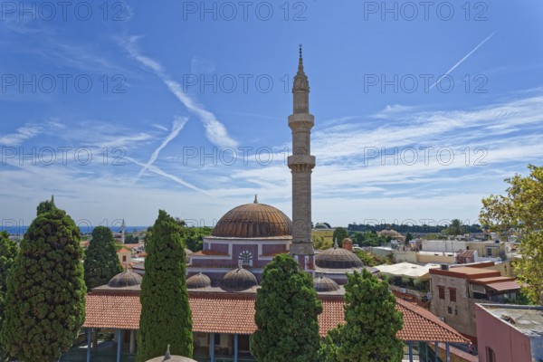 A minaret and domes in a tranquil cityscape with cypress trees and blue sky, Suleiman Mosque,