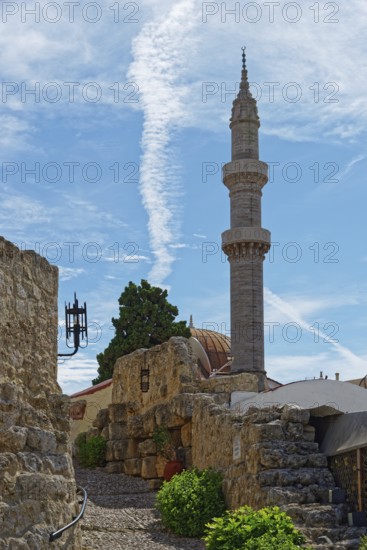 A minaret with a blue sky and ancient walls in a tranquil, historic setting, Suleiman Mosque,