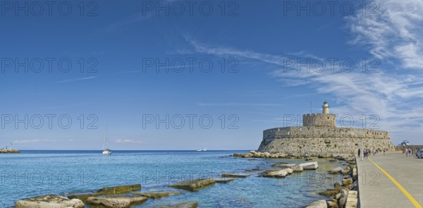 Fort of Saint Nikolaos stretches along the coast in the bright sunshine, Mandraki harbour, Medieval