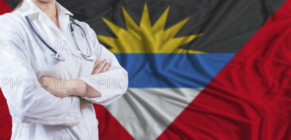 Doctor with crossed arms on Antigua and Barbuda flag. Antigua and Barbuda health and care concept.