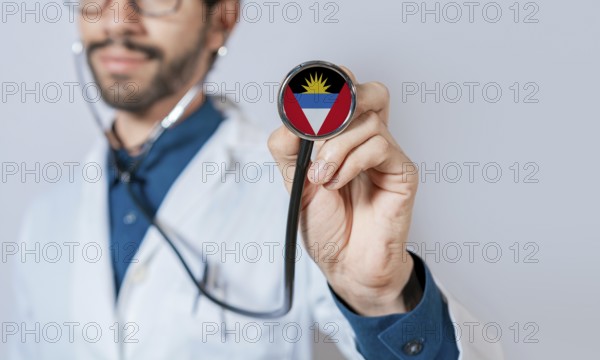 Doctor holding stethoscope with Antigua and Barbuda flag. Antigua and Barbuda health and care