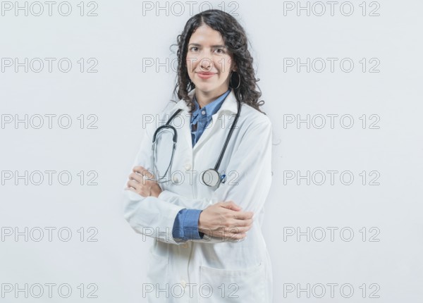 Portrait of smiling latin female doctor with crossed arms on isolated background. Success young