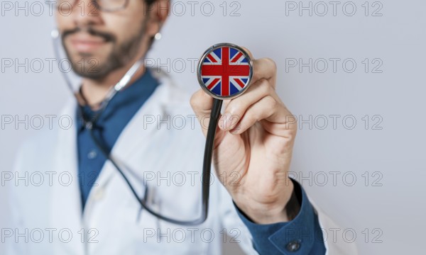 Doctor holding stethoscope with United Kingdom flag. United Kingdom health and care concept, United