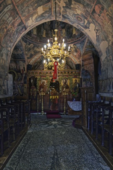 Magnificently decorated church interior with frescoes and a large candlestick that creates a
