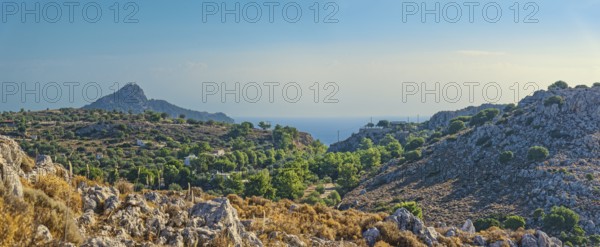 Hilly landscape near Stegna with green vegetation, sea view and blue sky, Stegna, Archangelos,
