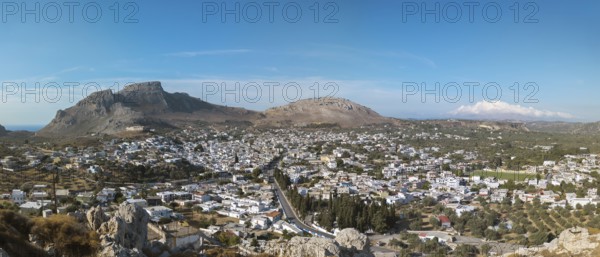 Panorama of the town of Archangelos in a sunny landscape, surrounded by mountains under a clear