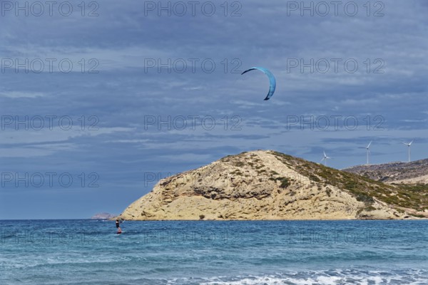 Prasonisi beach with a view of the sea and rocky island with visible kite and wind turbines. Windy