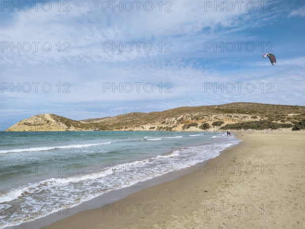 Quiet beach of Prasonisi with gentle waves and a kite in the sky under a slightly cloudy sky,