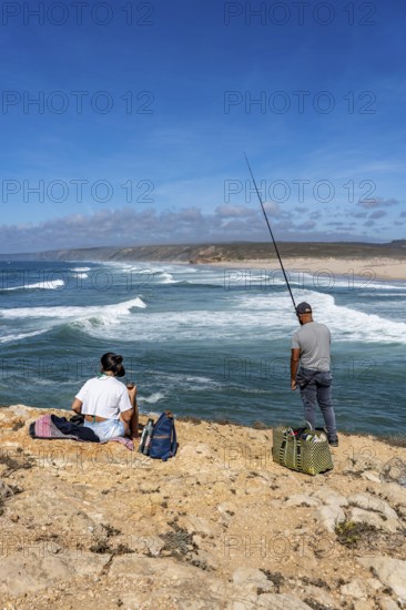 Anglers on the cliffs at the viewpoint above Praia da Bordeira beach, near Carrapateira, popular