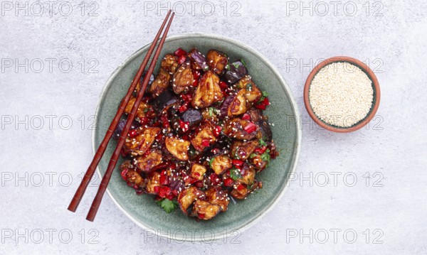 Fried eggplant, Chinese style, in sweet and sour sauce, with pepper and sesame seeds, in a green