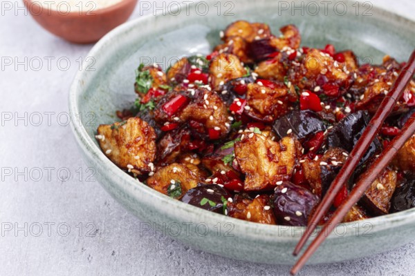 Fried eggplant, Chinese style, in sweet and sour sauce, with pepper and sesame seeds, in a green