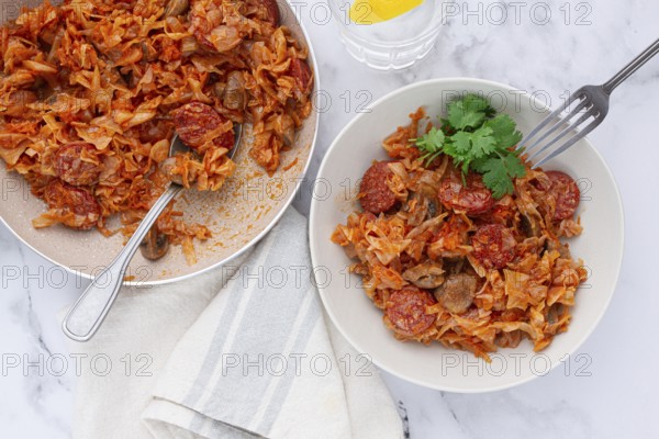 Bigos, Polish dish bigos, on the table, pan with stewed meat, with cabbage, chorizo sausages,